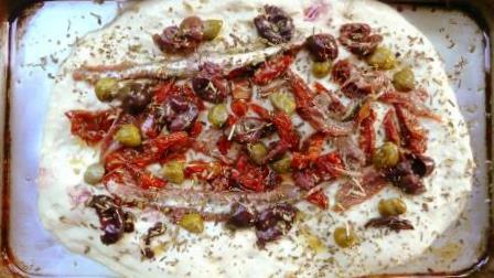 raw puttanesca on olive oil dough
